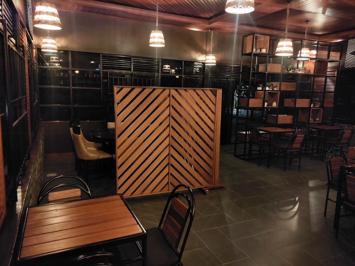 Bar and dining room at night with timber screens, pendant lights and seating