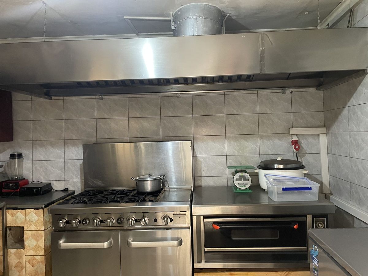 Commercial gas range and extractor hood in the kitchen