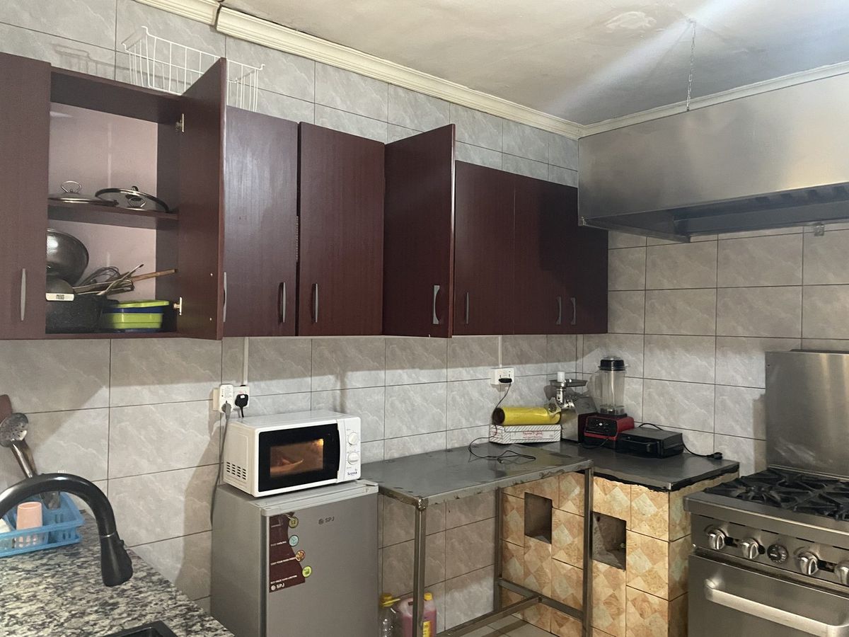 Kitchen prep counter with cabinets, microwave and cookware