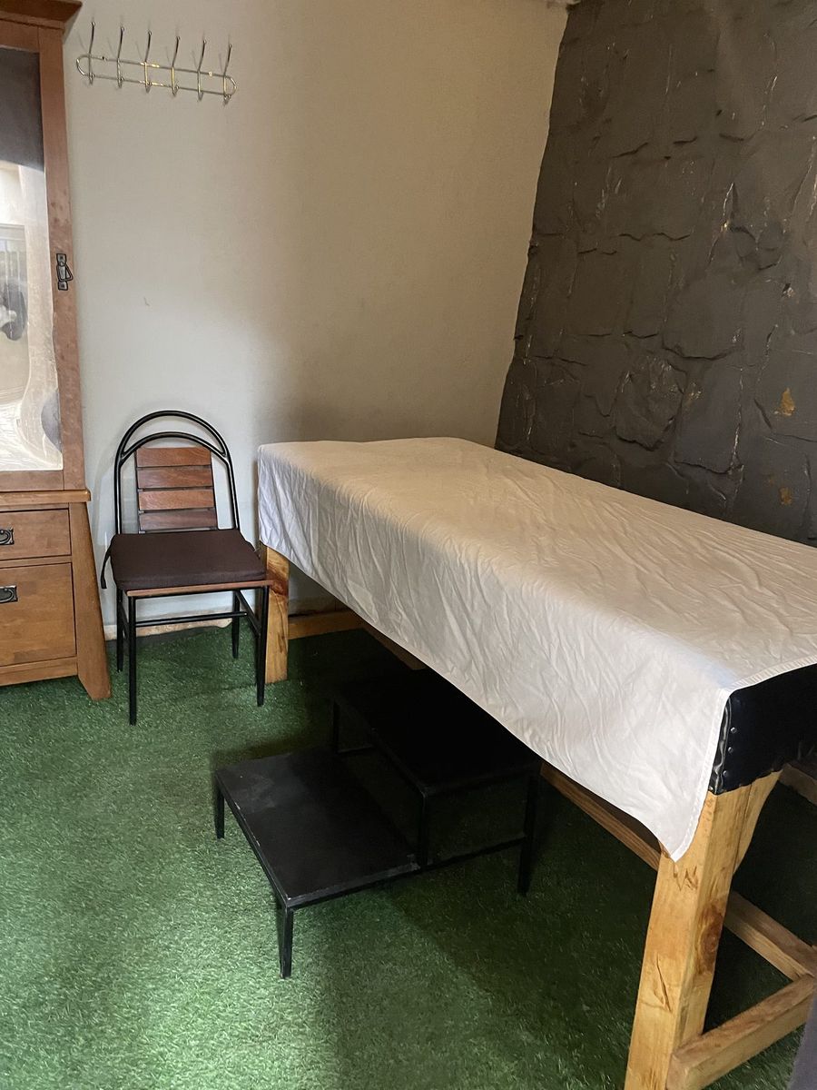 Massage table set up beside a chair in the treatment room