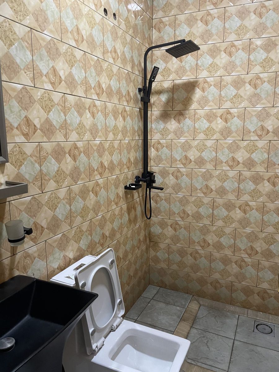 Shower with patterned wall tiles and a rain head