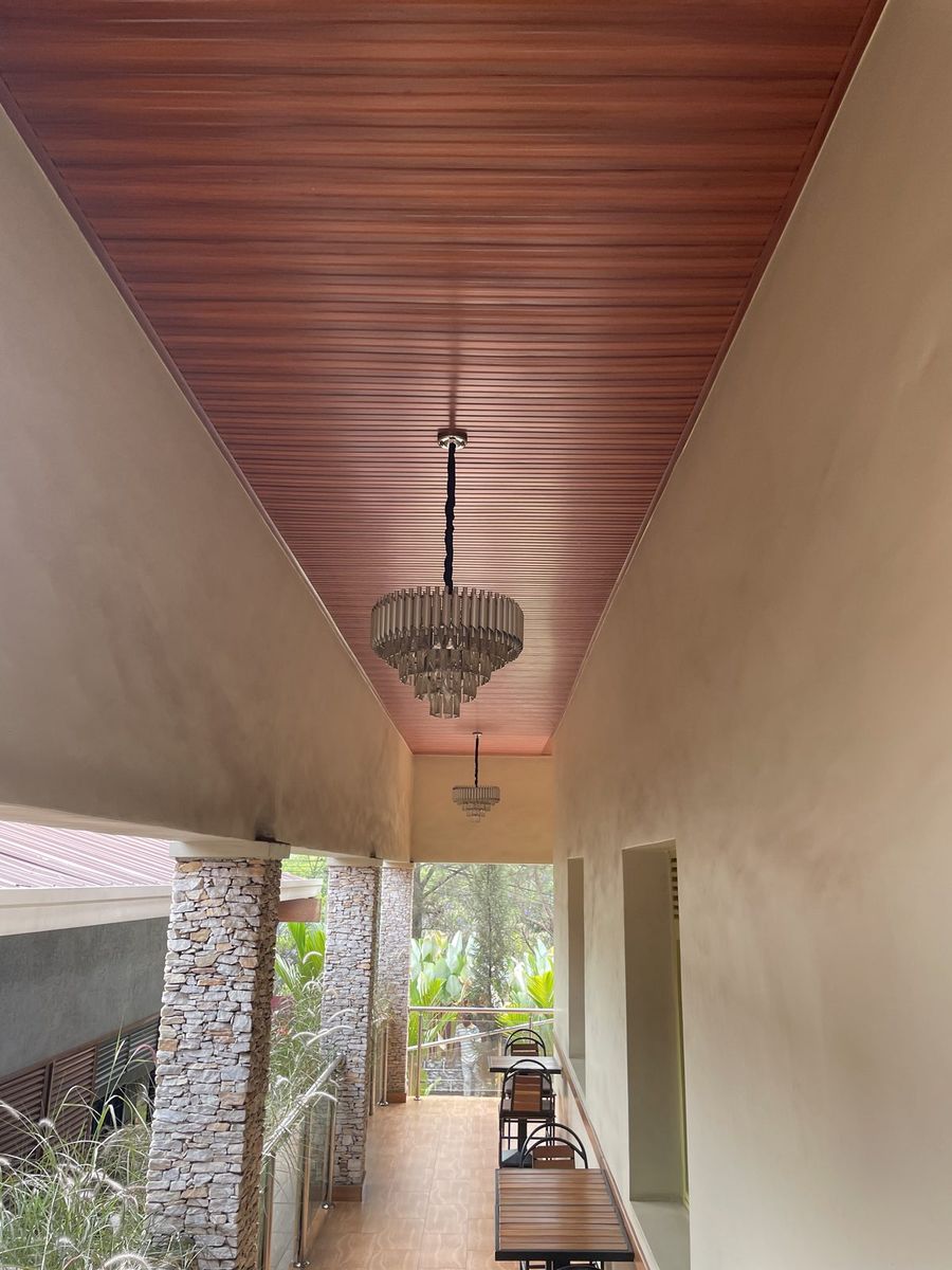 Covered walkway with a wood-panelled ceiling and hanging light