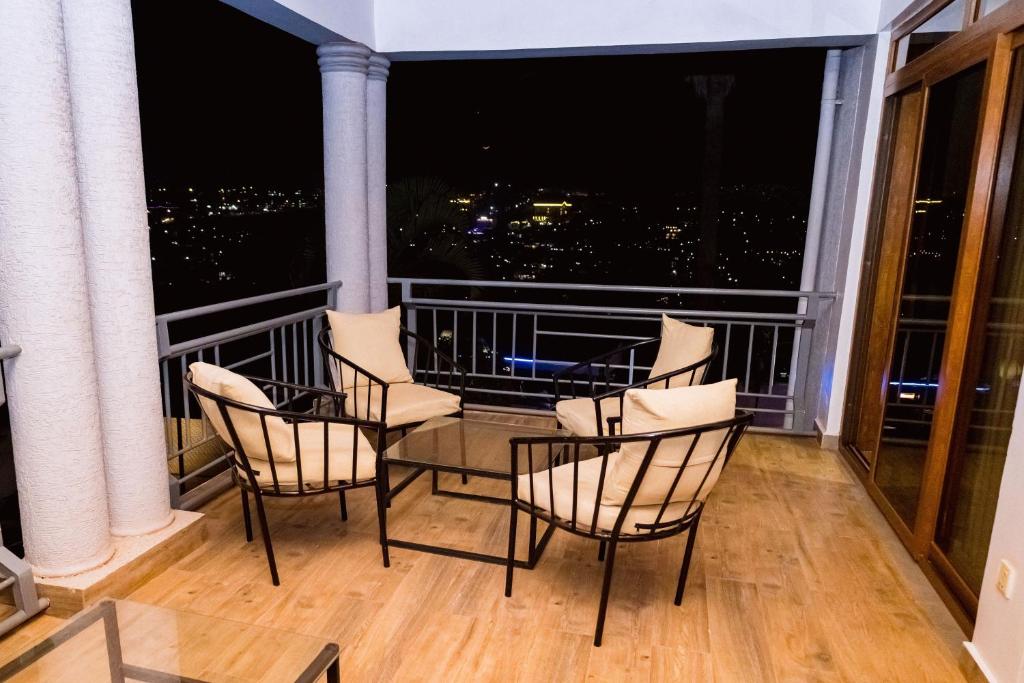 Private balcony with armchairs overlooking the lights of Kigali