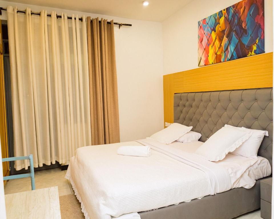 Deluxe room with grey tufted headboard and colourful artwork