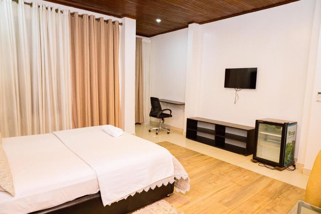 Deluxe room with television and desk facing the bed