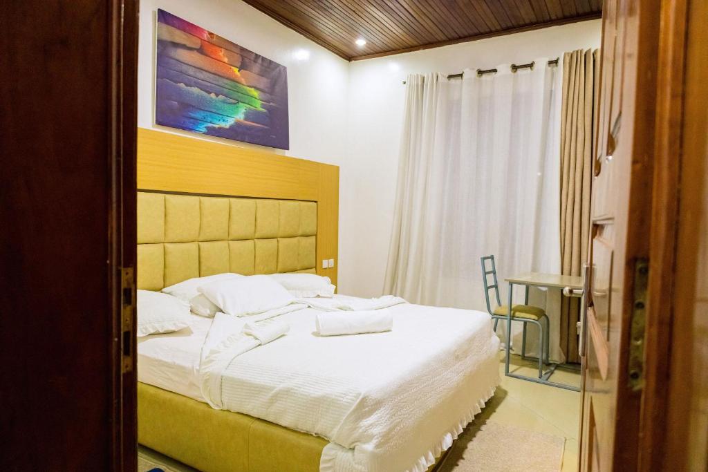 Deluxe double room with yellow padded headboard and wood ceiling