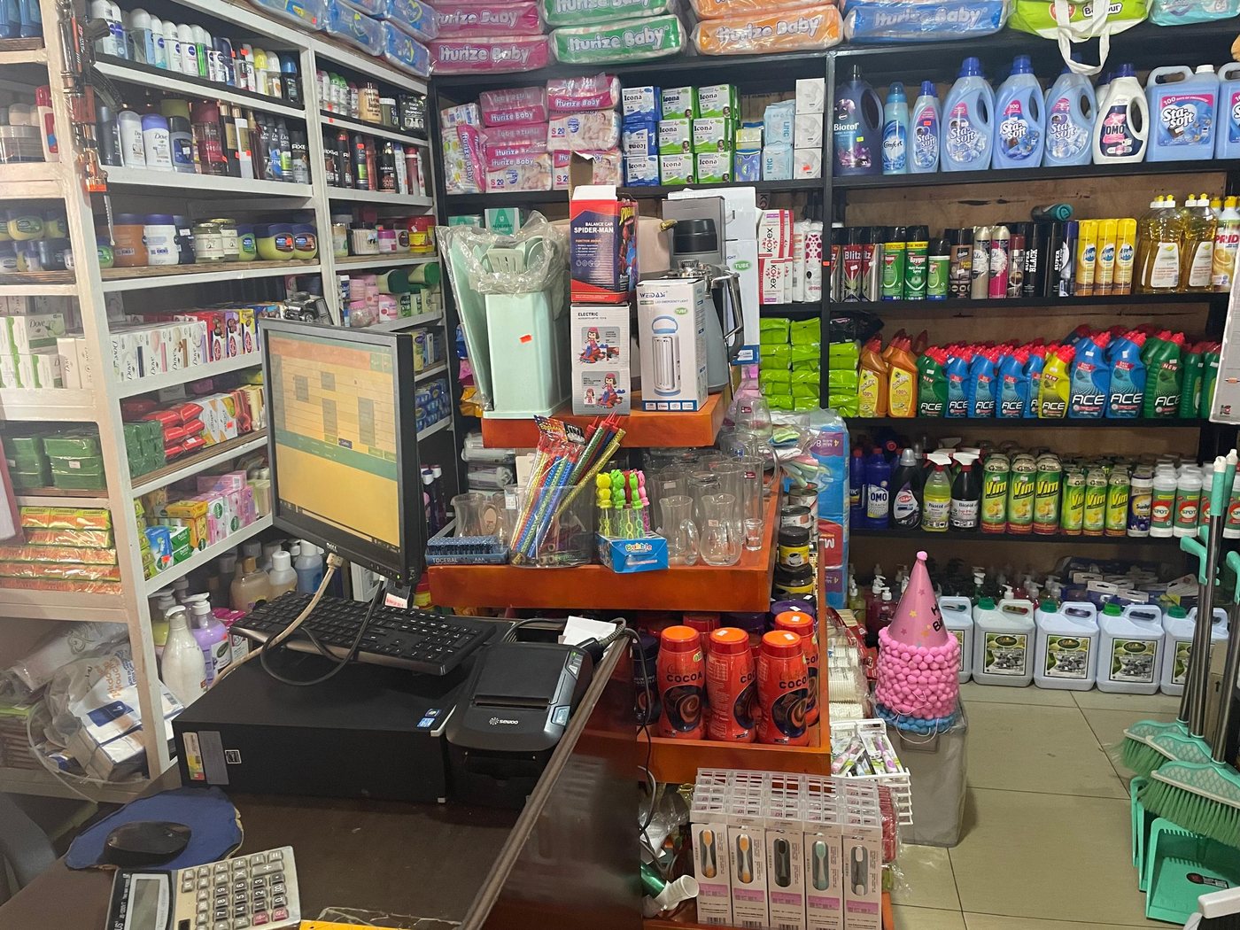 A Kigali supermarket counter running Sigeth Supermarket, with receipt printer and barcode scanner